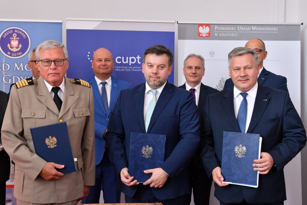 Od lewej: kpt.ż.w. Wiesław Piotrzkowsk, Dyrektor Urzędu Morskiego w Gdyni, Przemysław Gorgol, p.o. Dyrektora CUPT i Adam Meller, Prezes gdyńskiego portu. Z tyłu od lewej - Wiceminister Inwestycji i Rozwoju Witold Słowik i Wojewoda Dariusz Drelich.