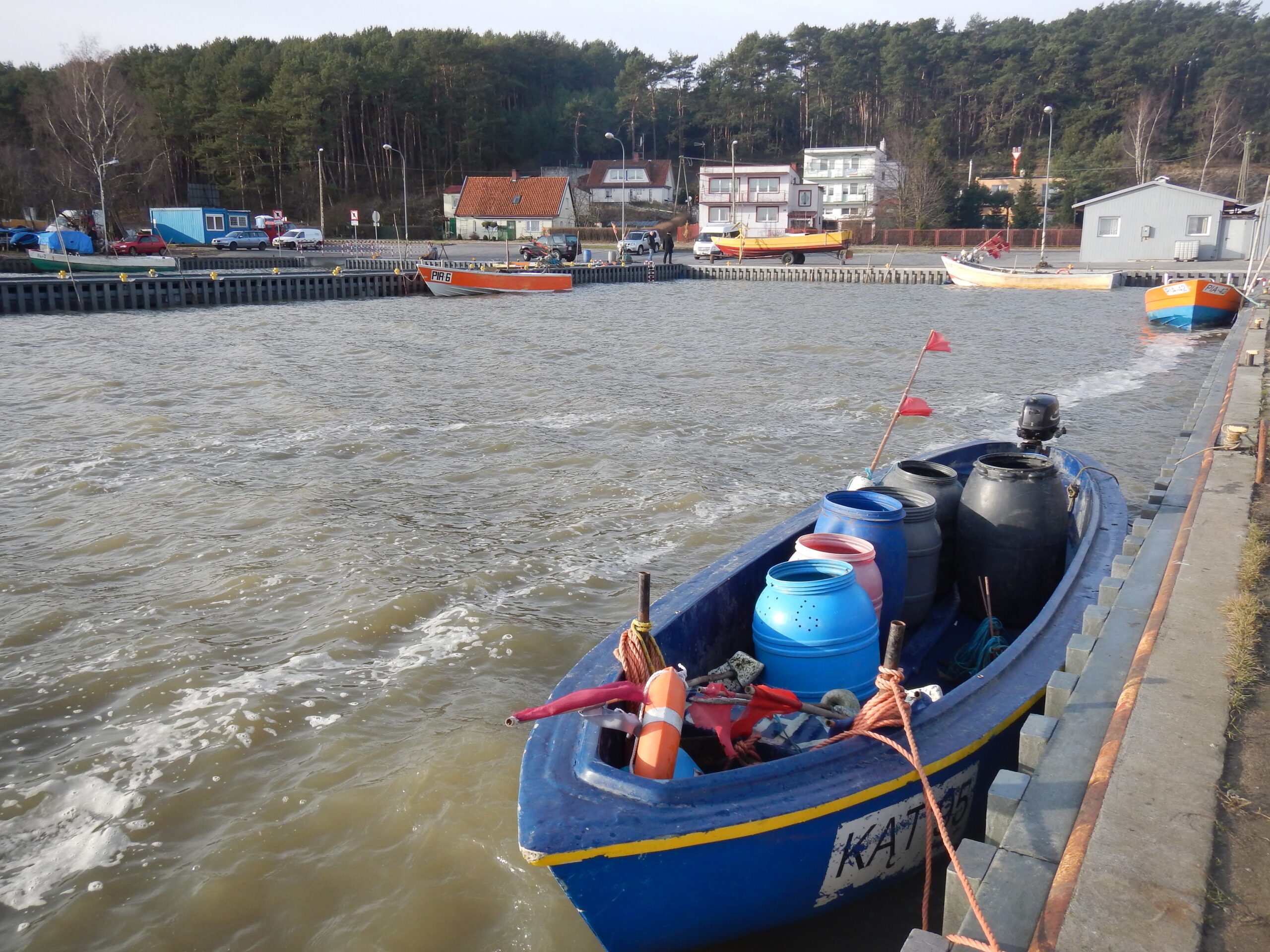 widok z falochronu na port z łodziami